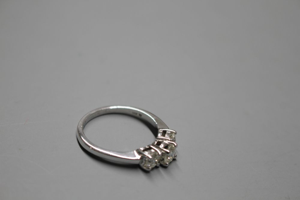 A modern 14k white metal and three stone diamond ring,